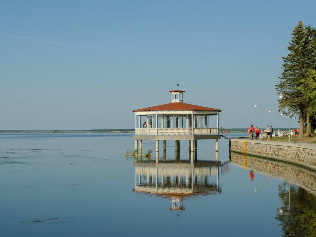 Pavelló de fusta del passeig de Haapsalu reflectit a la badia en calma
