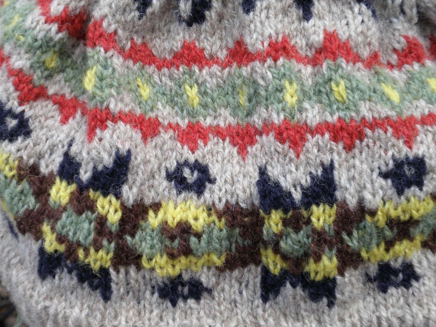 Detall d’un jersei de punt Fair Isle amb motius vermells, grocs i blaus