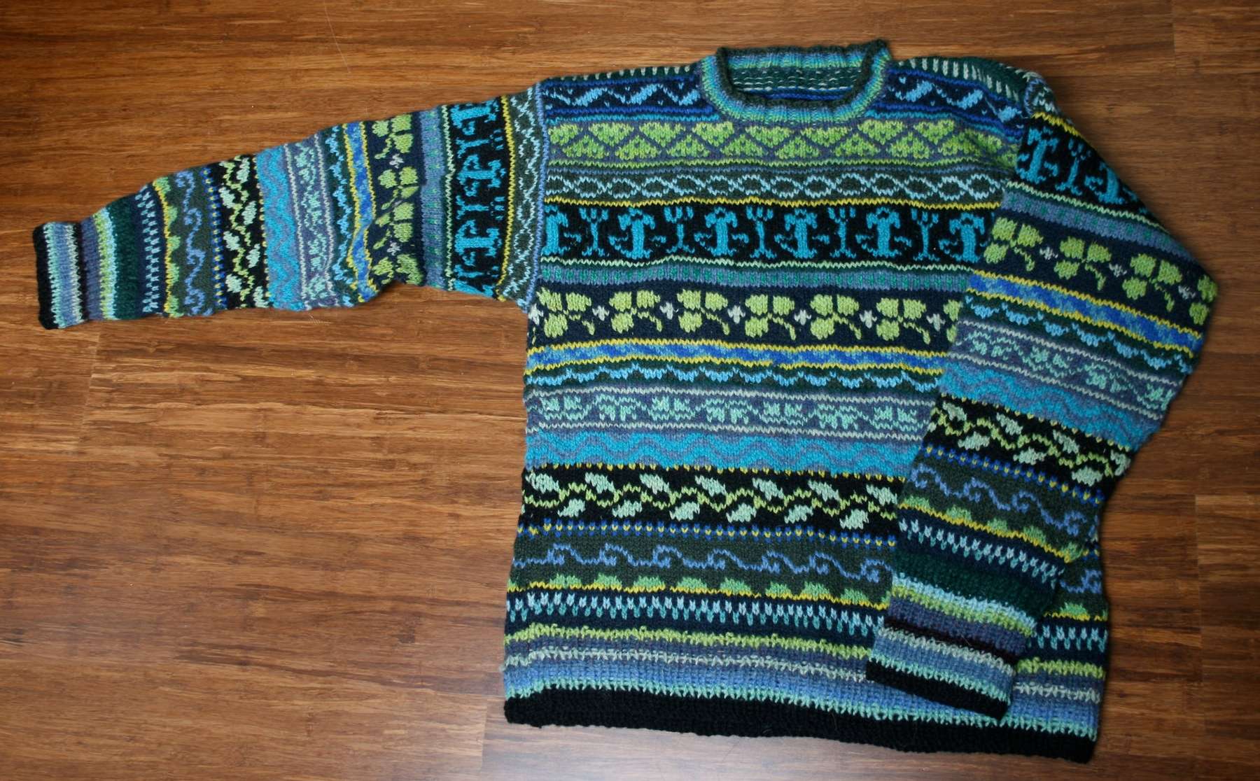 Jersei de punt Fair Isle en blaus i verds estès sobre el parquet