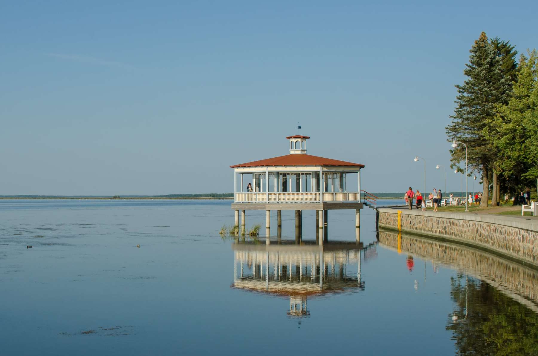 Pavelló de fusta del passeig de Haapsalu reflectit a la badia en calma