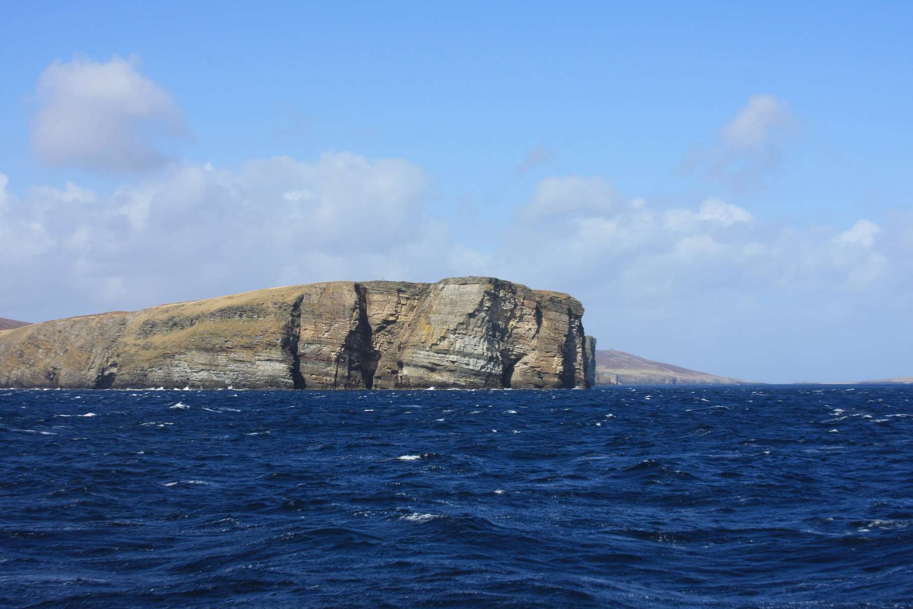 Penya-segats d’una illa de Shetland sobre un mar blau intens
