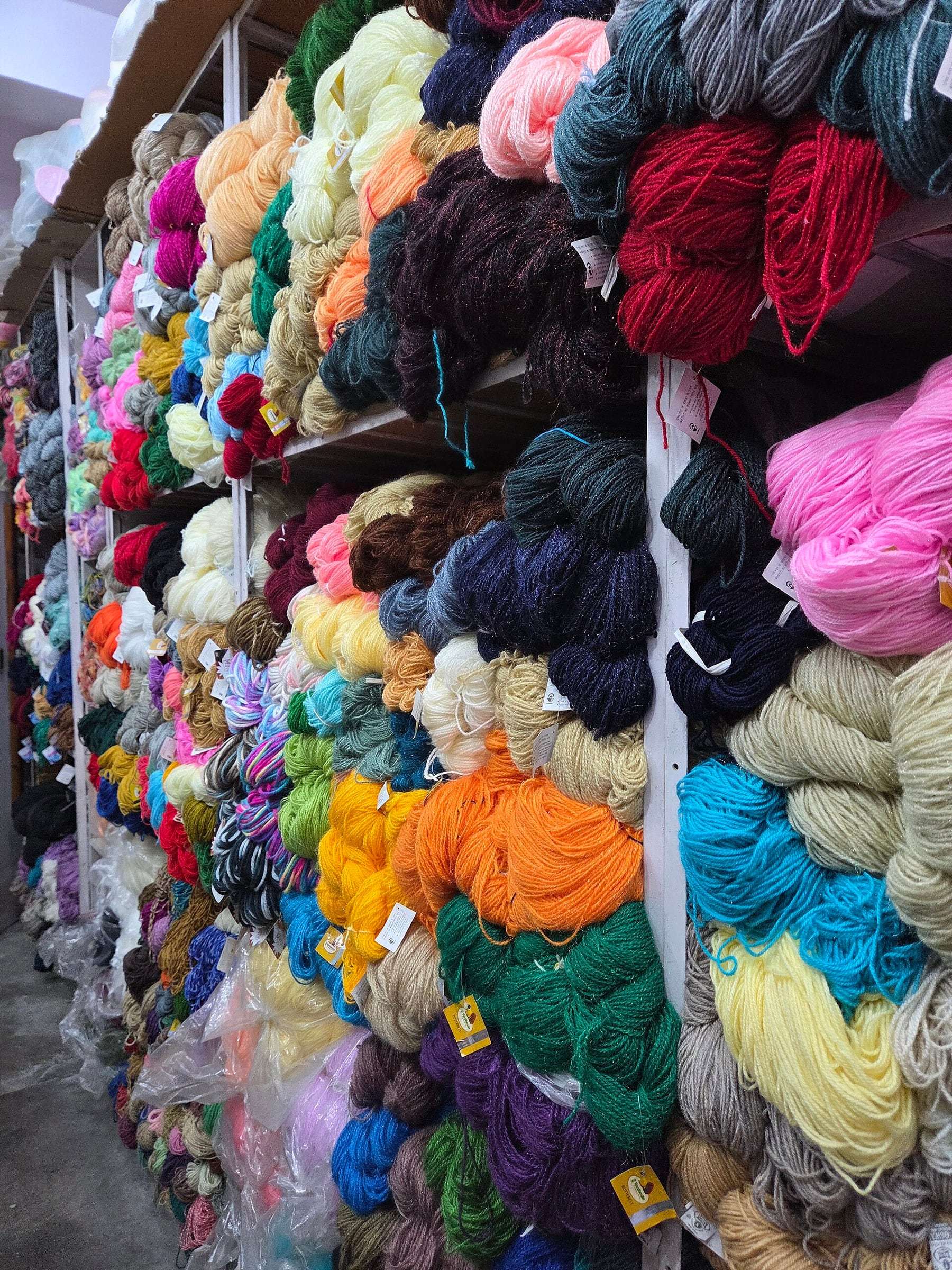 Paret de madeixes de colors en una botiga de llana