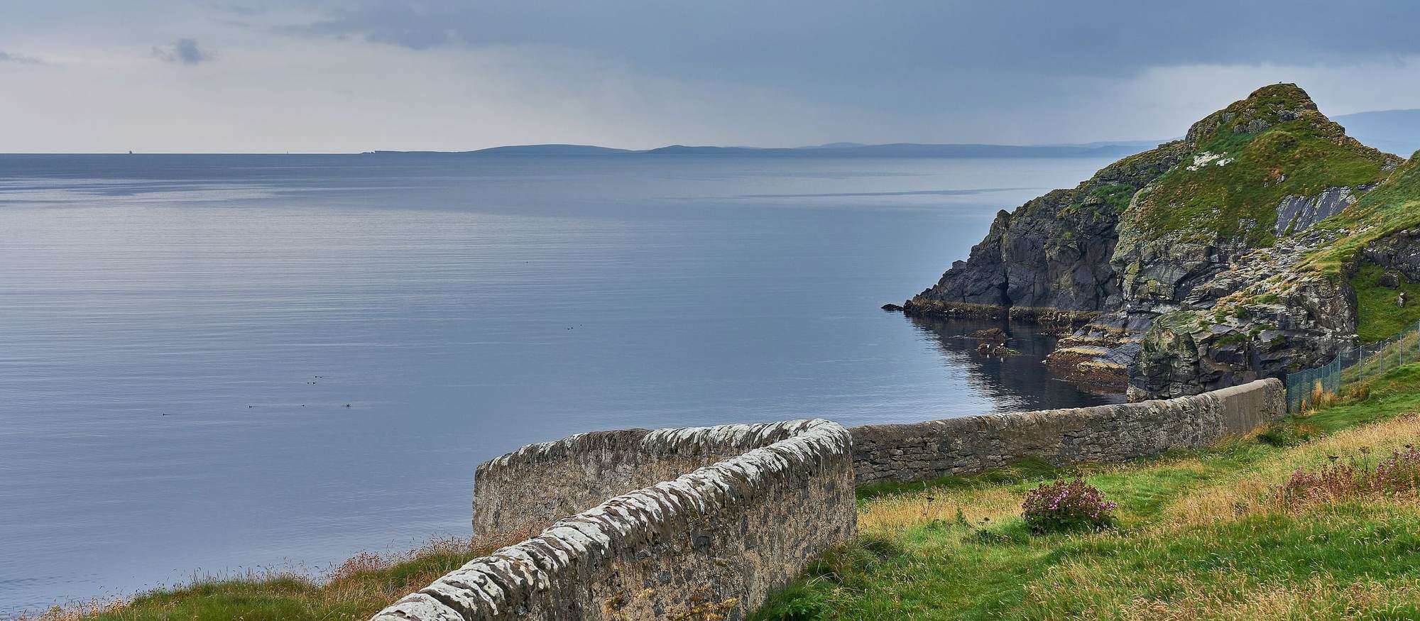 Costa de Shetland amb un mur de pedra seca i el mar al fons