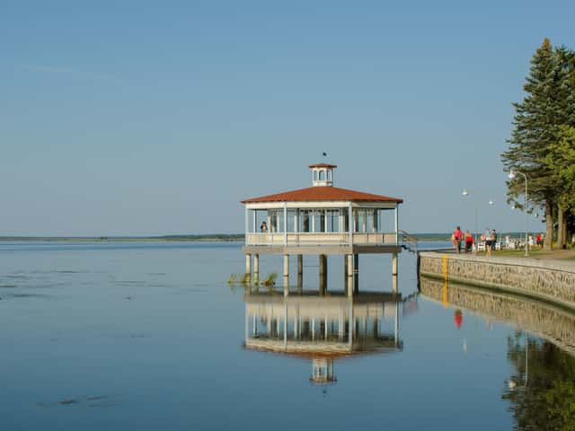 Pavelló de fusta del passeig de Haapsalu reflectit a la badia en calma