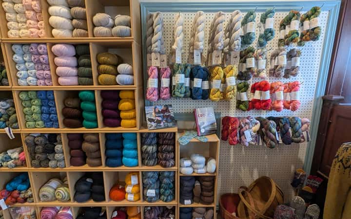 Botiga de llana amb prestatgeries plenes de madeixes de colors
