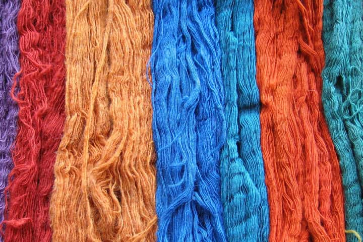 Madeixes de llana tenyides amb tints naturals en taronja, blau i vermell